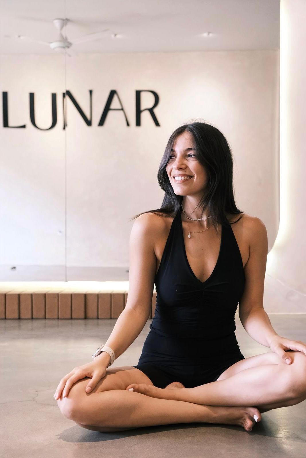 Noa, founder of LUNAR, with the LUNAR sign behind her
